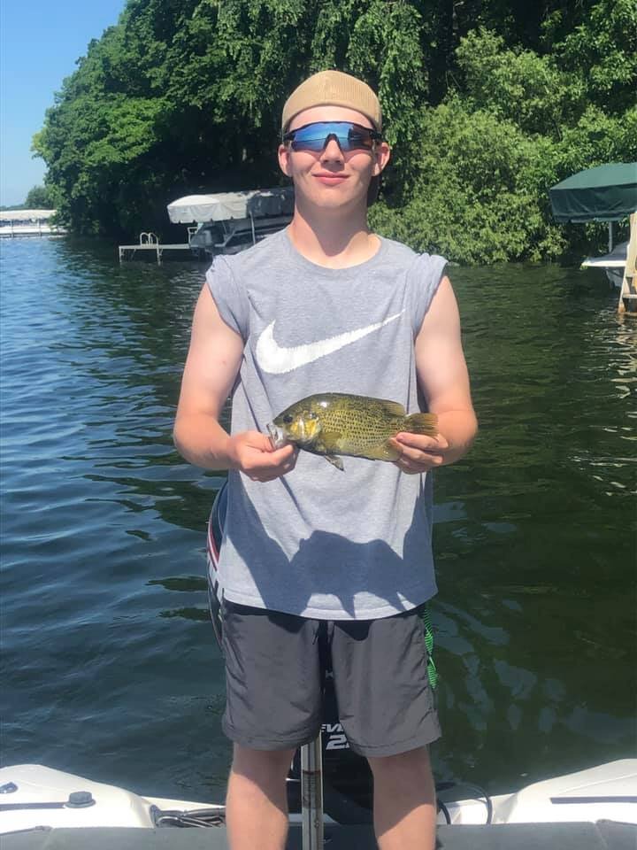 teenager holding fish with sunglasses